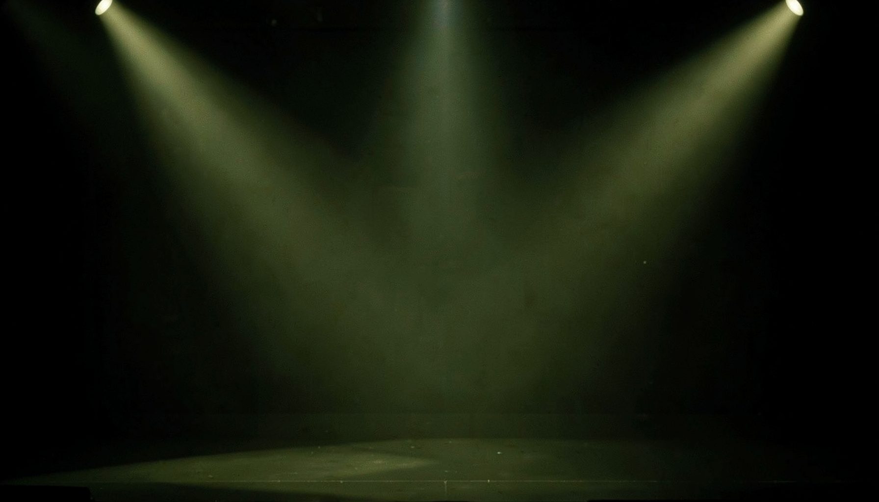 Empty dark stage with three spotlight beams shining down through haze, greenish tones, dramatic mood